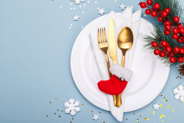 Christmas or new year table setting with golden cutlery on the blue background with copy space - Zdjęcie, obraz