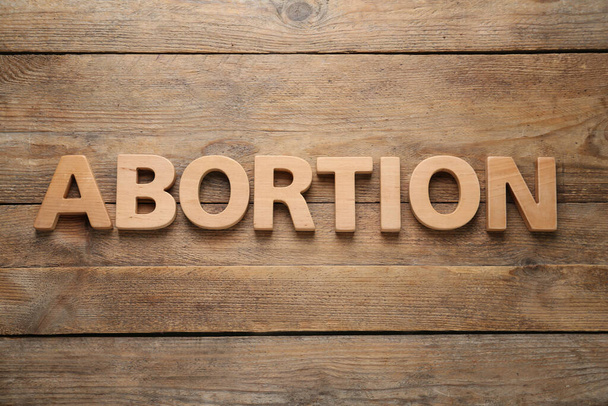 Word Abortion made of letters on wooden background, flat lay - Photo, Image