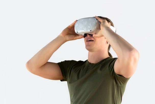 Молодий чоловік використовує гарнітуру віртуальної реальності. Ізольовані на сірому фоні
. - Фото, зображення