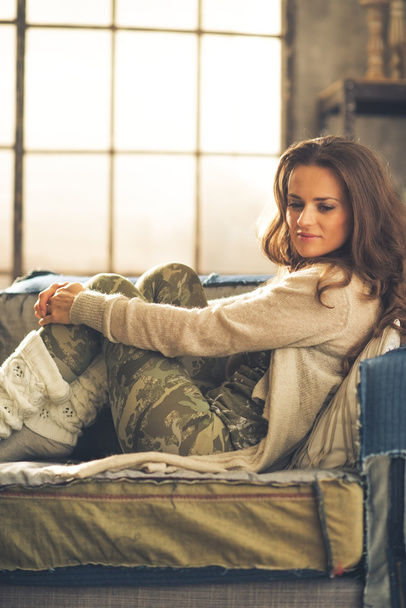 Στοχαστικός νεαρή γυναίκα που κάθεται στο διαμέρισμα σοφίτας - Φωτογραφία, εικόνα