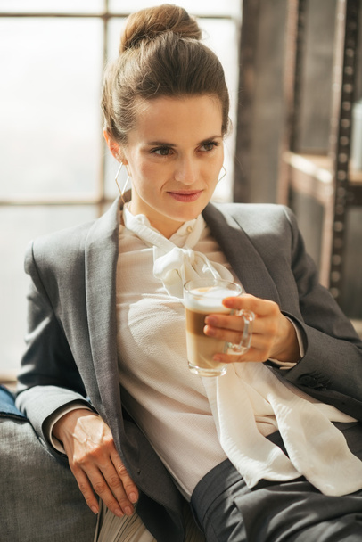 Business woman with coffee latte relaxing in loft apartment - Фото, зображення