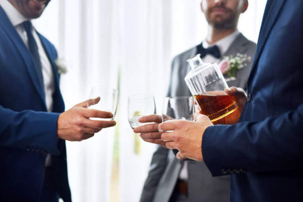 Lets share a drink together on this special day. two unrecognizable groomsmen sharing a toast with the bridegroom on his wedding day - Zdjęcie, obraz