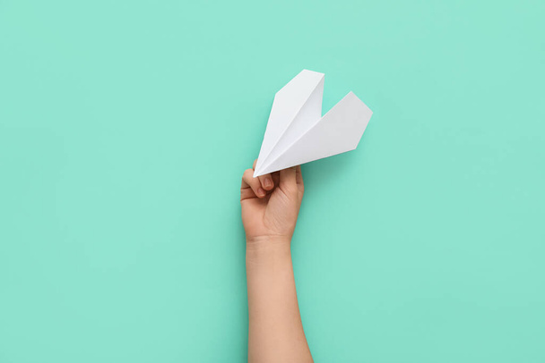 Woman with white paper plane on color background - Foto, Bild