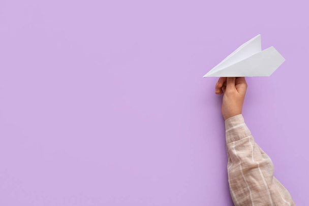 Woman with white paper plane on lilac background - Foto, immagini