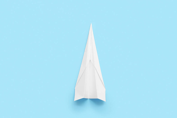 White paper plane on blue background - Foto, afbeelding