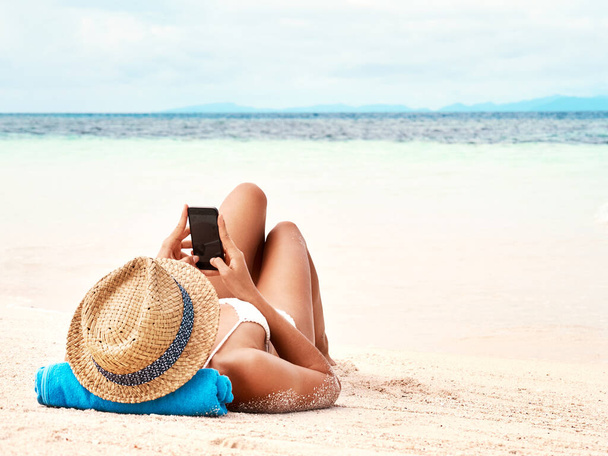 Выключи телефон, расслабься. Снимок молодой женщины с помощью смартфона во время отдыха на пляже - Фото, изображение