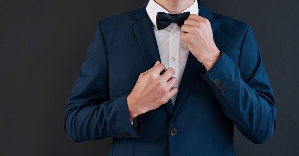 Its his day, hes gotta have the best tie. an unrecognizable bridegroom adjusting his bowtie in preparation for his wedding - Foto, Bild