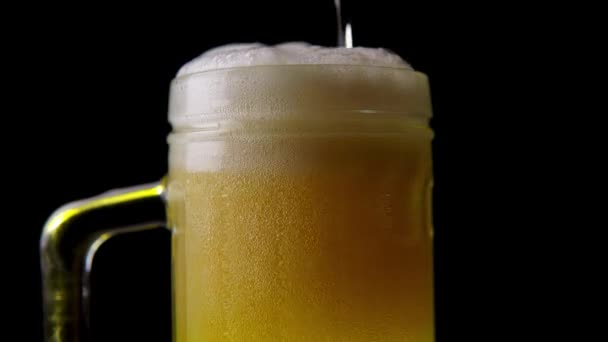 Beer. Cold Craft light Beer in a glass with water drops. Pint of Beer close up on a wooden background. Beer is pouring from the bottle. Border design. High quality 4k footage. High quality 4k footage - Materiał filmowy, wideo