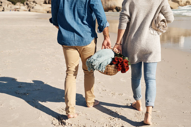 A date on the beach will do you good. an unrecognizable couple walking together on the beach - Foto, imagen