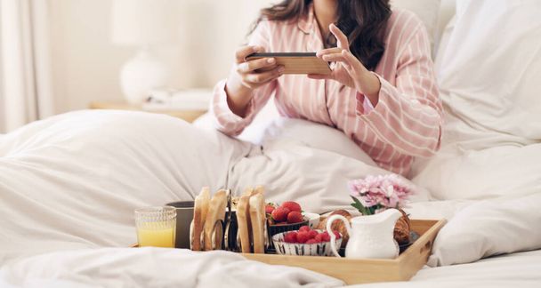 Так я начинаю свое утро. женщина фотографирует свой завтрак в постели дома - Фото, изображение