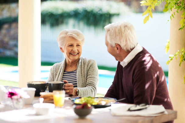Счастье написано на ее лице. ласковая пожилая пара, наслаждающаяся совместным ужином на открытом воздухе - Фото, изображение