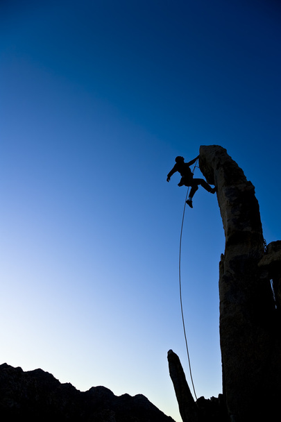 Альпинист, свисающий с вершины
. - Фото, изображение