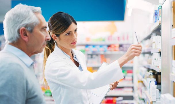 If you want my advice, take this one. a pharmacist assisting a customer in a chemist - 写真・画像