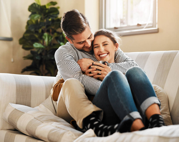 Did you say you want to cuddle. a young couple relaxing on the sofa at home - Foto, Imagem