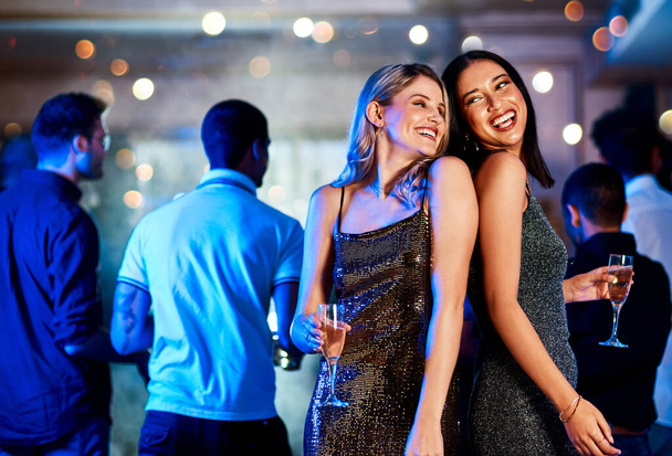 We are on fire. two cheerful young women having drinks while dancing on the dance floor of a club at night - Fotoğraf, Görsel