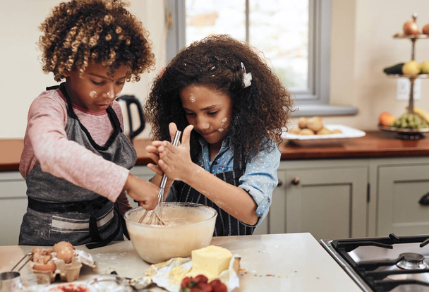 Trying moms flop proof recipe. a young boy and girl baking in the kitchen at home - Foto, Bild