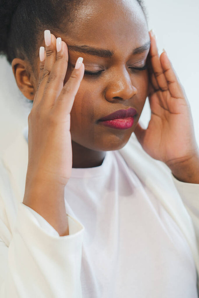 Portrait of an african woman suffering from a terrible headache. Stress and frustration concept. Depression and pain concept. - Foto, Imagen