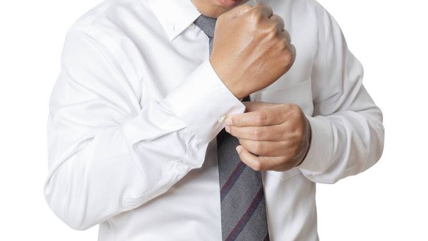 Portrait of businessman wearing white shirt adjusting his cuff links. Human emotion expression concept. Studio shot isolated on white background. copy space - Photo, image