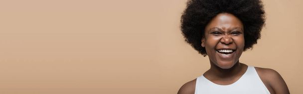 πορτρέτο της χαρούμενης Αφροαμερικανή συν μέγεθος γυναίκα απομονωμένη σε μπεζ, banner - Φωτογραφία, εικόνα