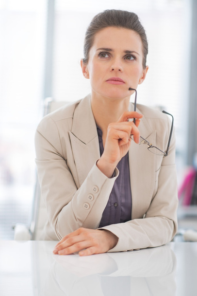 Portrait of thoughtful business woman with eyeglasses in office - 写真・画像
