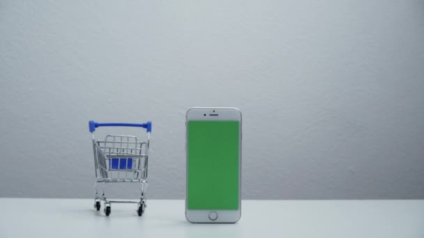 stop motion a cart shopping moving around smart phone green screen. - Metraje, vídeo