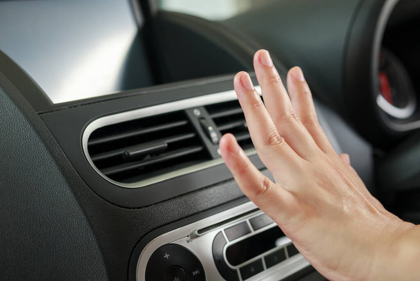 hand checking air conditioner system inside the car - 写真・画像