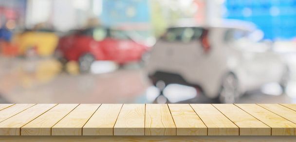 Lege houten tafelblad met auto 's in showroom wazig gedeconcentreerde achtergrond - Foto, afbeelding