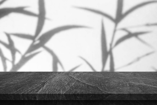 Mármol mesa superior con sombra de árbol gota en fondo blanco de la pared para la exhibición del producto de maqueta - Foto, imagen