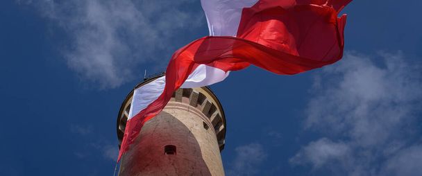 BANDERA ESTATAL Bandera de Polonia en el faro de Swinoujscie - Foto, imagen