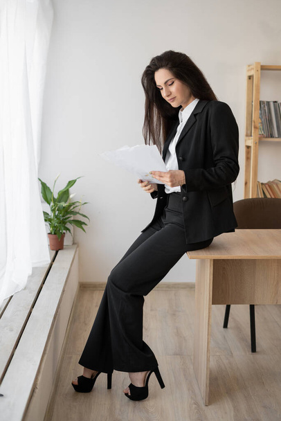 Stylish business woman reading papers or tax report at office. business, finance and people concept - Foto, immagini