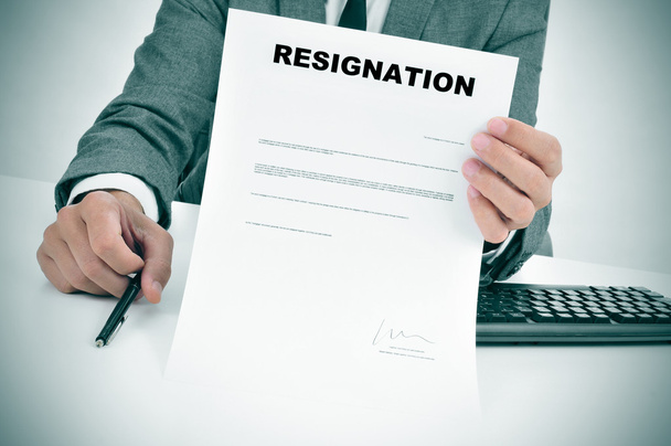 Mann im Anzug zeigt ein signiertes Rücktrittsdokument - Foto, Bild