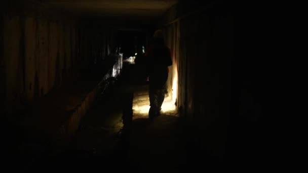 Młoda koparka z latarką bada tunel. - Materiał filmowy, wideo