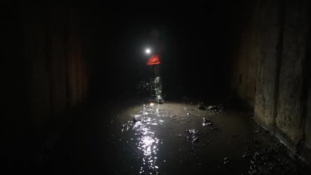 Una giovane scavatrice con una torcia esplora il tunnel - Filmati, video