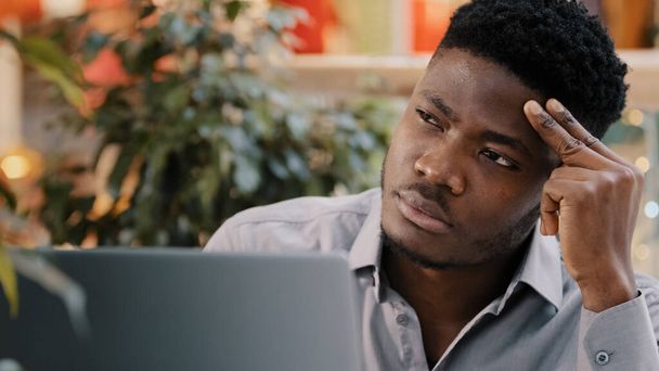 Close-up young male businessman looking at laptop screen receiving email reading shocking bad news surprised shocked upset by information holding his head distressed hopelessness dismissal bankruptcy - Fotó, kép