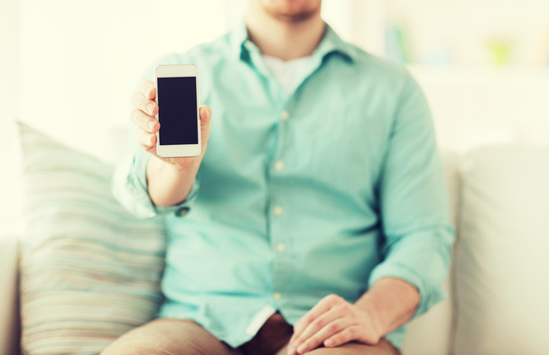 close up of man sitting with smartphone at home - Fotó, kép