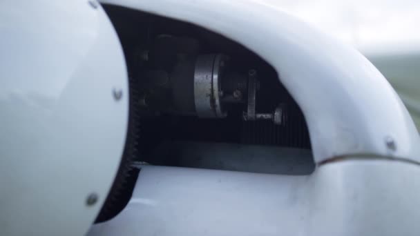Closeup small plane engine under white aircraft hood turned off. Technical part of ultralight private airplane parked on aerodrome after flight. Modern components air transport. Aviation concept. - Video