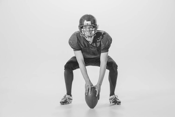Portrait of young man, american football player posing. Black and white photography. Cheerful, smiling sportsman. Concept of sport, retro style, 20s, fashion, action, college sport, youth - Foto, Imagen