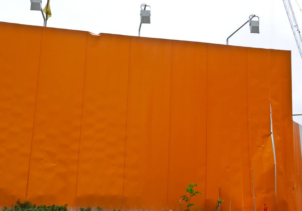Большая темно-оранжевая стена рекламного пространства с зеленым вегетарионом на полу - Фото, изображение