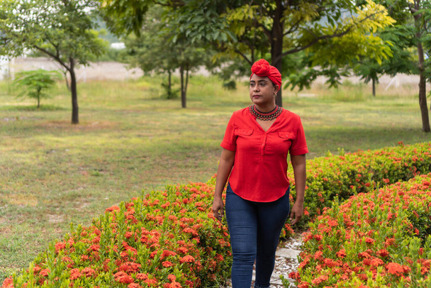 Афроженщина с тюрбаном гуляет по парку - Фото, изображение