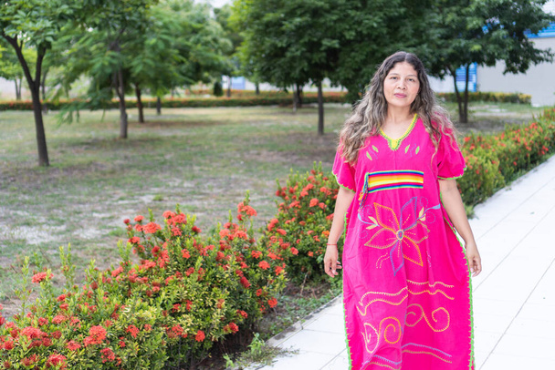 Портрет латиноамериканки, гуляющей в традиционной одежде в городском парке. - Фото, изображение