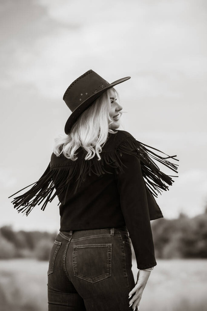 Woman in American country style,  suede leather boho jacket and cowboy hat at nature - Foto, immagini