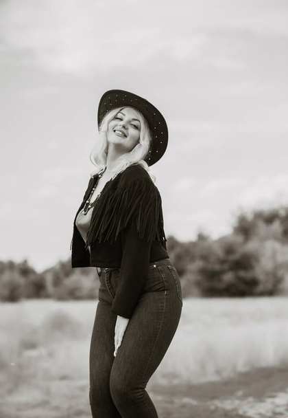 Woman in American country style,  suede leather boho jacket and cowboy hat at nature - Fotoğraf, Görsel