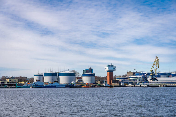 Terminal of cargo international seaport of Klaipeda, Lithuania. Cargo ship, loading and fuel tanks - Photo, image