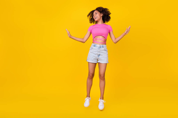 Full size photo of funny brunette millennial lady jump wear top shorts shoes isolated on orange color background. - Fotografie, Obrázek