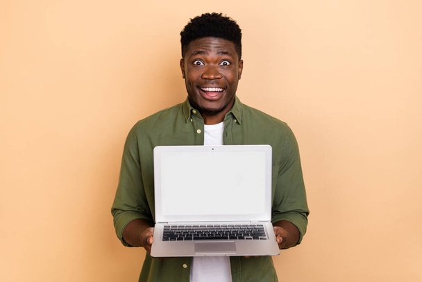 Photo of excited crazy guy hold netbook demonstrate electronics device discounts isolated pastel color background. - Фото, зображення