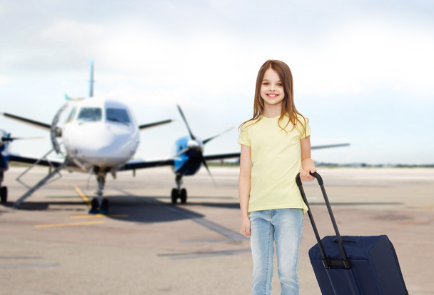 smiling girl with travel bag in airport - Fotó, kép