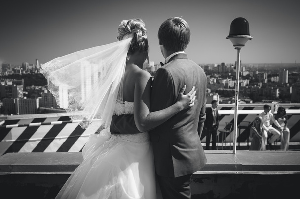 Schwarz-Weiß-Aufnahme von Braut und Bräutigam mit Blick auf die Stadt - Foto, Bild