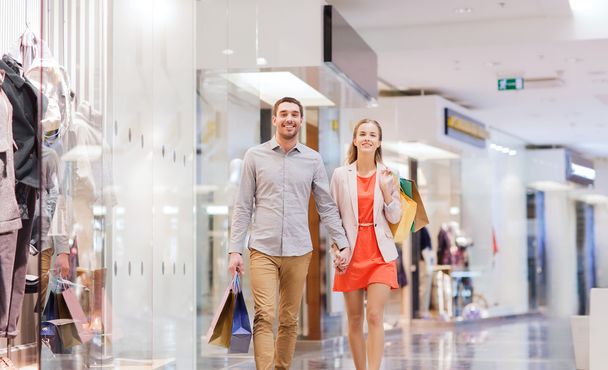 happy young couple with shopping bags in mall - Foto, imagen