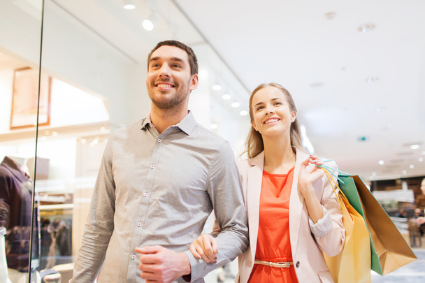 happy young couple with shopping bags in mall - Foto, immagini