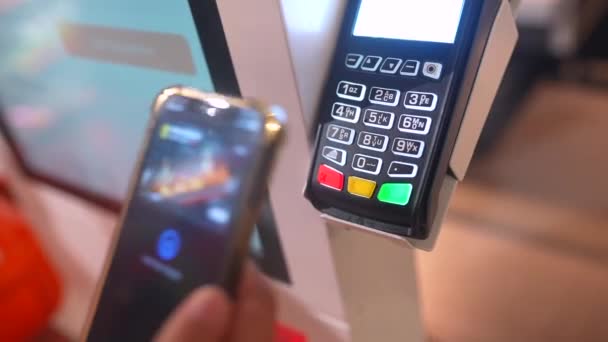 Az okostelefonnal rendelkező és a hitelkártyaolvasó NFC-technológiájával fizető okos emberek levágott képe - Felvétel, videó